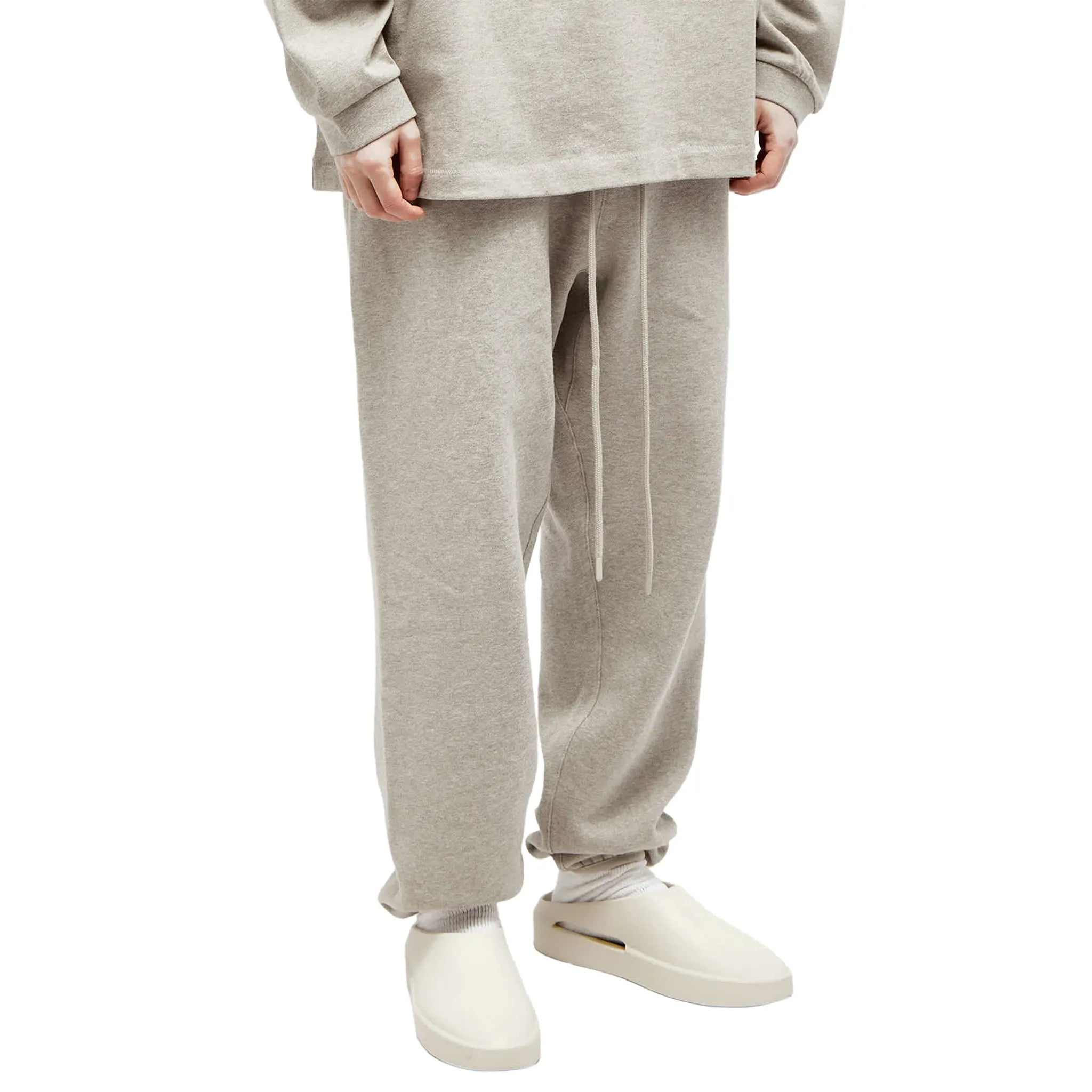 Model Front Side View of Fear Of God Essentials Core Collection Dark Heather Oatmeal Sweatpants (FW23) 130SP242023F